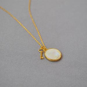 Brass pendant necklaces with round mother shell and key gold plated